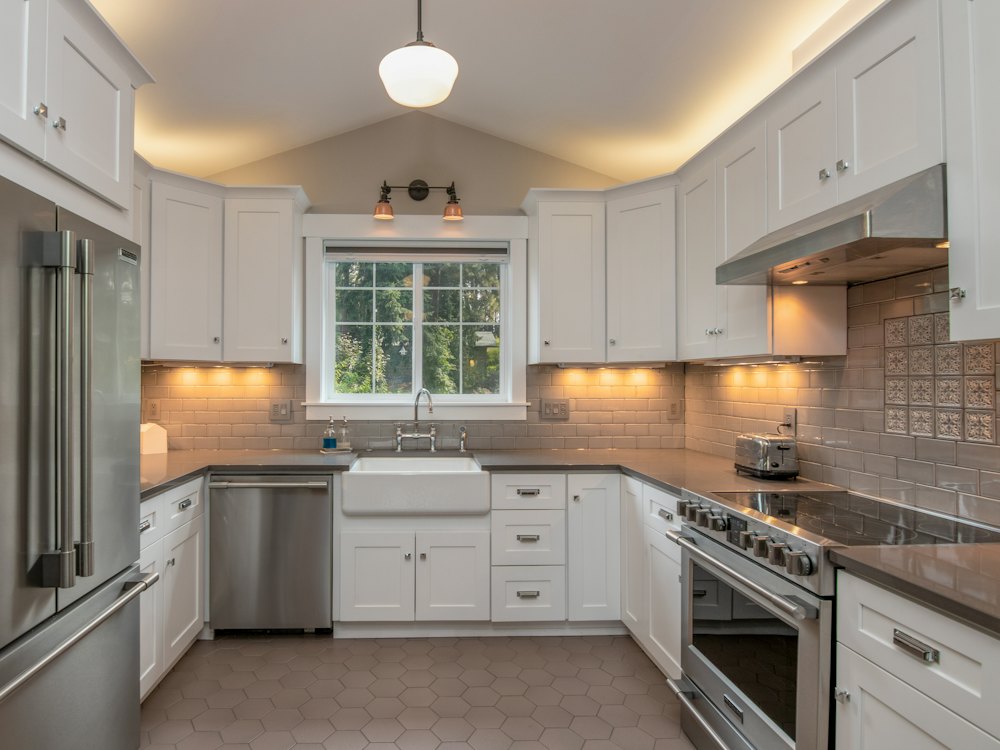 White kitchen cabinets with a white pendant lamp